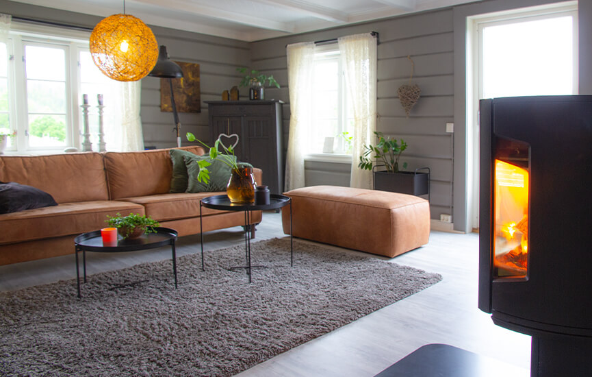 Puuhella harmaassa olohuoneessa puuseinät ja ruskea sohva