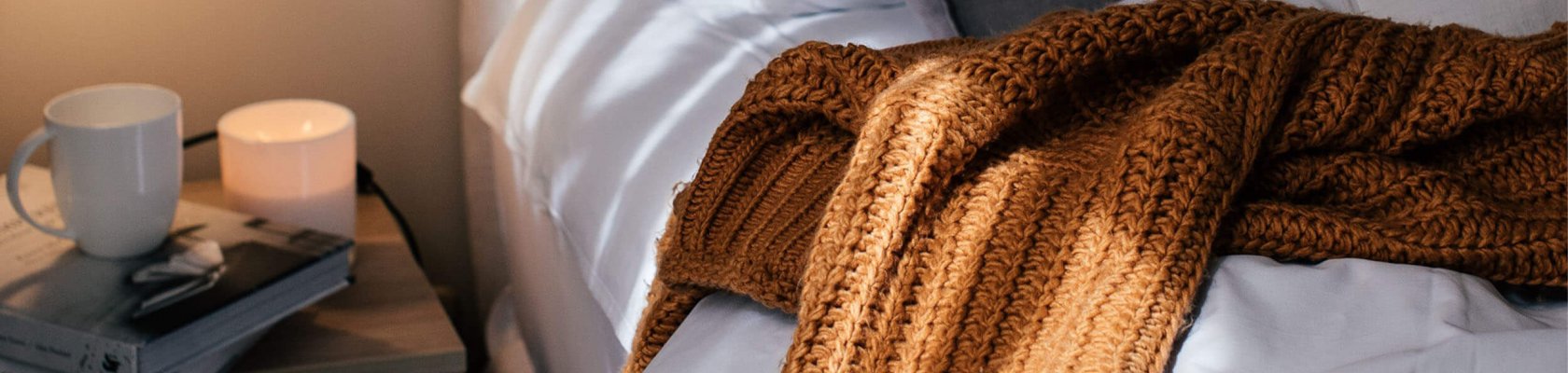 Mukava peitto ja kahvikuppi sängyllä