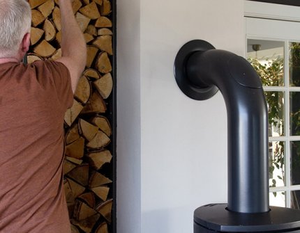 Mies vie puita laittaakseen takkaan