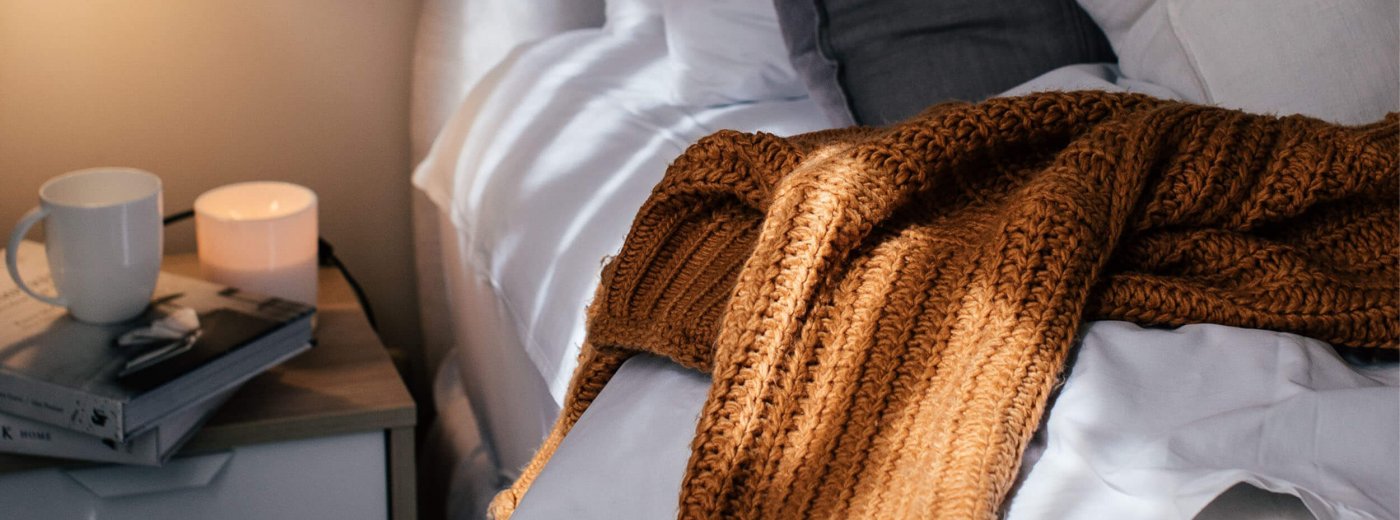 Mukava peitto ja kahvikuppi sängyllä