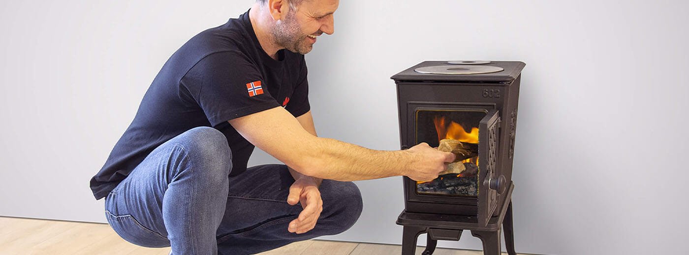Mies laittaa puita Jøtul F 602 -puutakaan