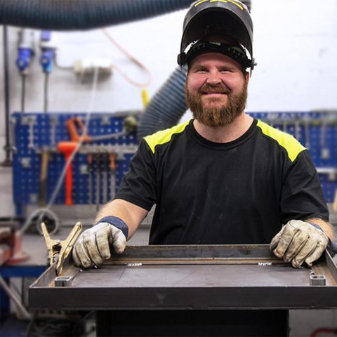 Mann som jobber i Jøtul fabrikk med verksted bak seg.